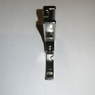 Piedino per chiusura lampo per macchina industriale con foro a destra.